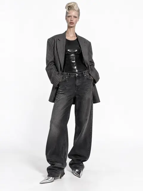 AI character in a gray blazer and wide-leg jeans